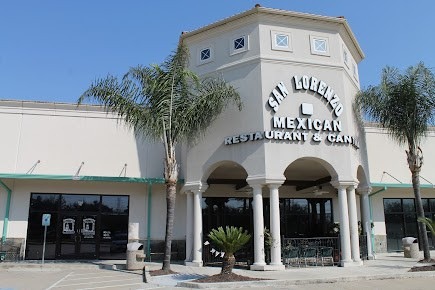 a restaurant with a clock tower and palm trees