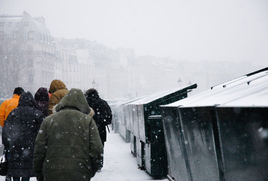 People walking in the snow along River Seine in Paris
