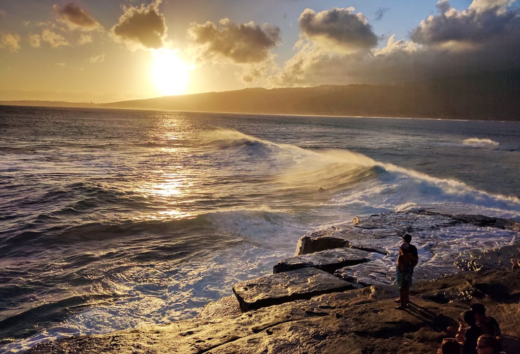 Photo of a person having a numinous experience before a sunset on the sea