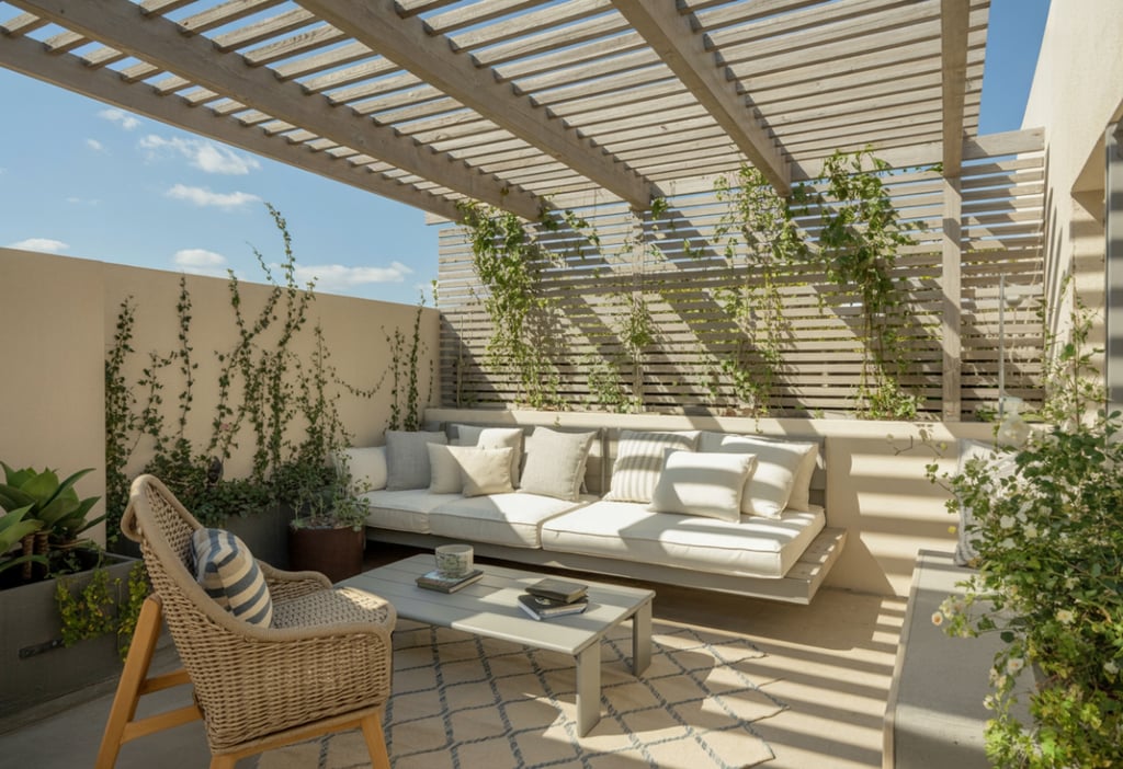 Pergola roof reading nook with slatted wood overhead, sunlight filtering through, climbing plants st