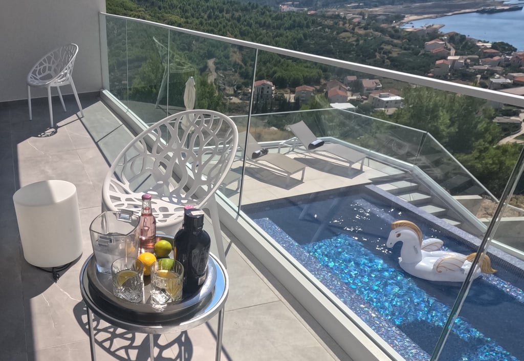 Villa Fay balcony with a table with a tray of drinks and a swan in the pool