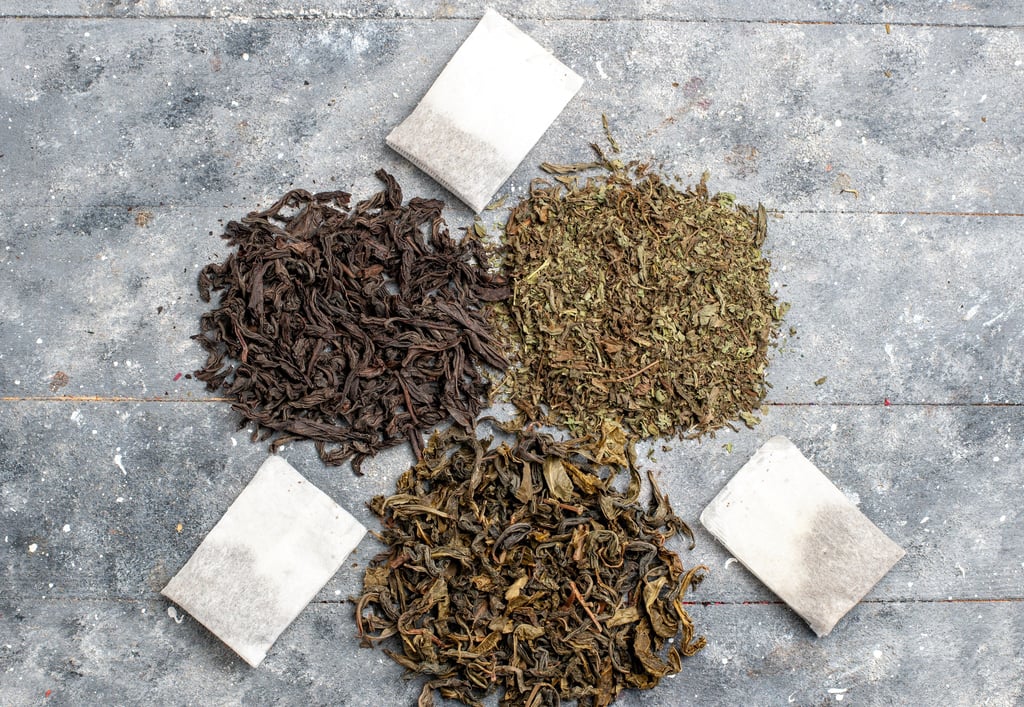 Loose Hojicha tea and tea bags displayed on a grey surface.