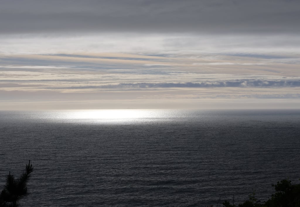 Sunlight reflecting on the Pacific Ocean at Muir Beach with layered clouds and calm coastal California horizon