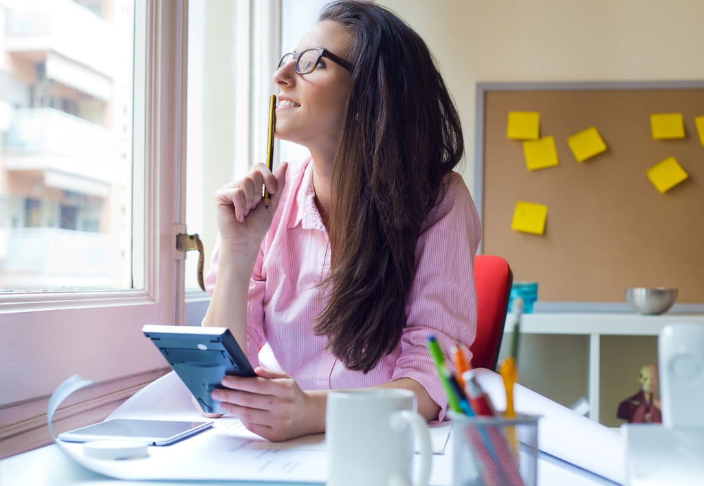 a woman sitting at a desk with a note pad and pen