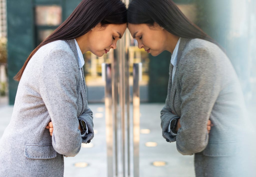 a sad women standing in front of a glass door