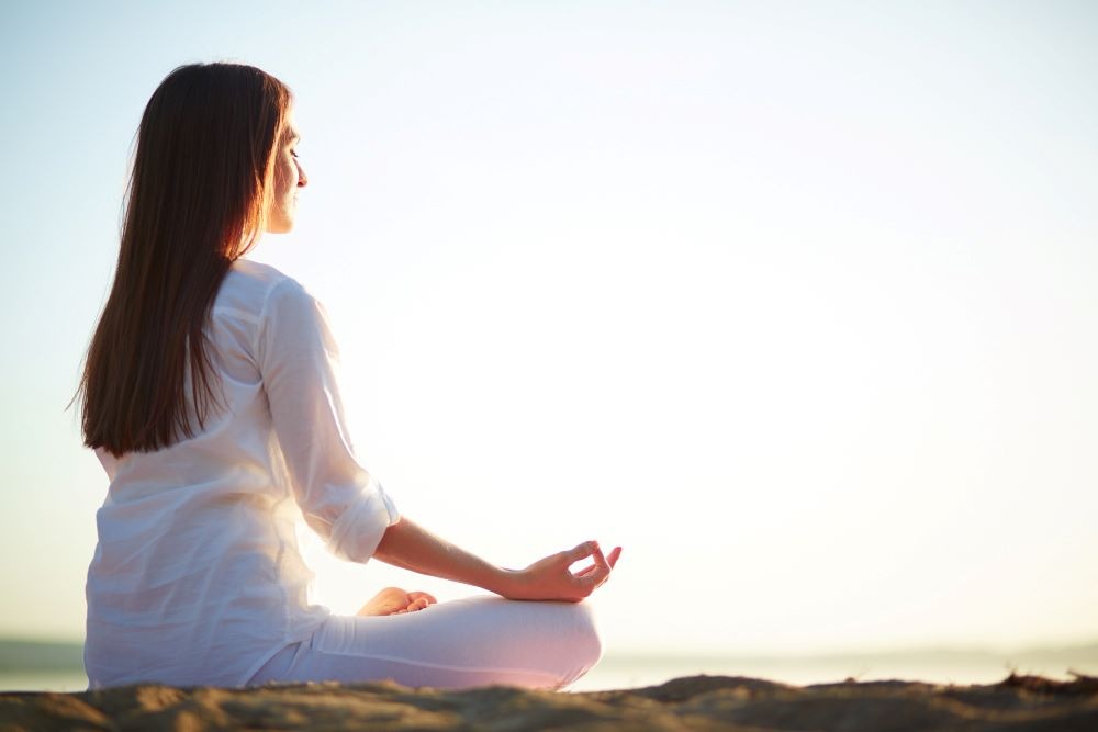a woman sitting in a meditation position