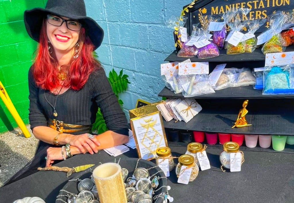 a woman in a witch hat at a market booth