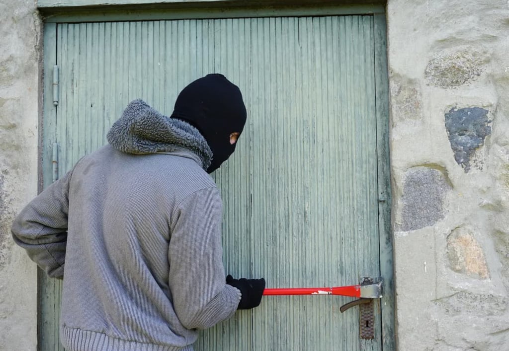 Le cambrioleur en action sur une porte de maison