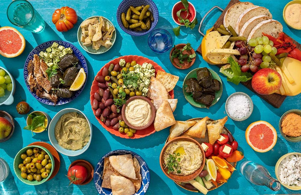 "Traditional Greek dishes including moussaka, souvlaki, and dolmades served with fresh ingredients l