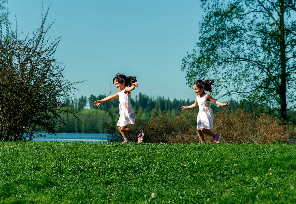 two young girls playing in grass field