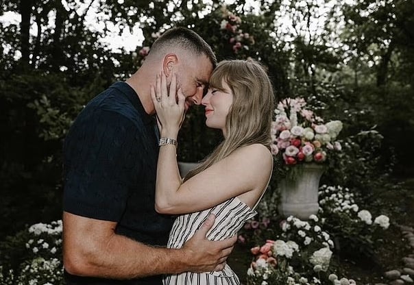 Taylor Swift and fiancé Travis Kelce sharing emotional moment after engagement proposal surrounded by flowers.