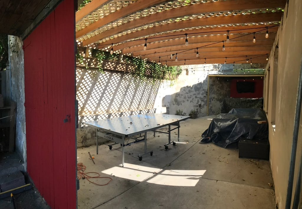 Outdoor garage man cave with bar, TV, and roof overhand performed by Golden Rule Construction