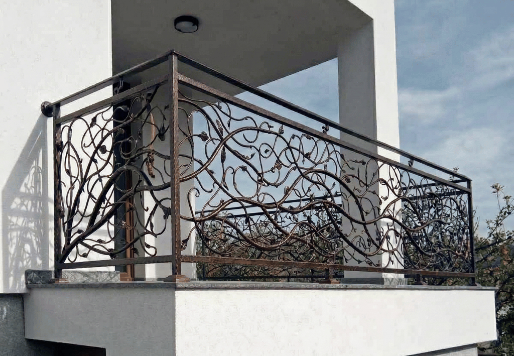 Custom decorative wrought iron balcony railing with an intricate vine and leaf design.