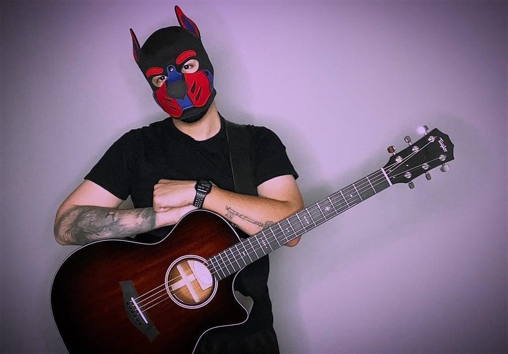 Man in pup mask with a guitar