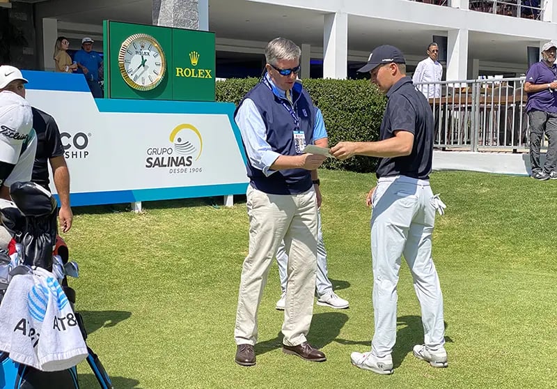 Casey handing Jordan Speith his scorecard.