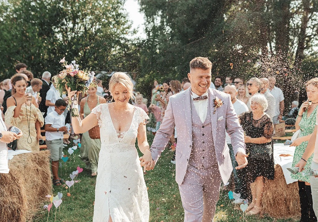 ortie de cérémonie laïque avec lancer de pétales pour un couple de mariés heureux.