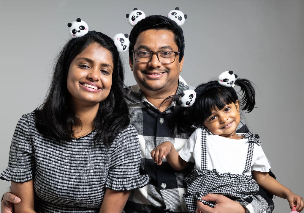 a man and woman in panda hats with a little girl