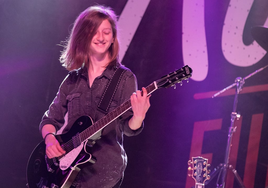 Seattle Guitar Academy a woman in a black shirt playing guitar