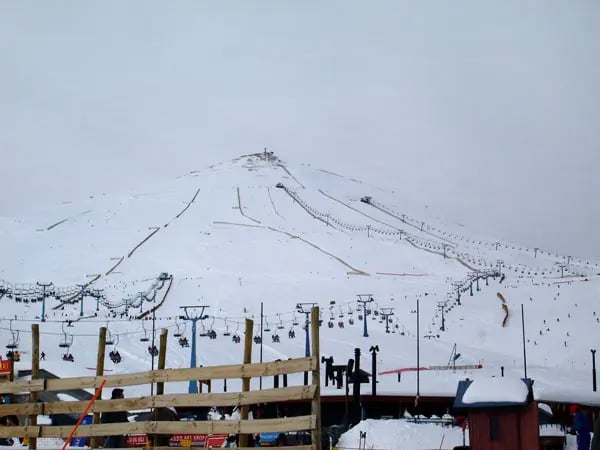 a ski lift in the snow with a mountain in the background valle nevado chile