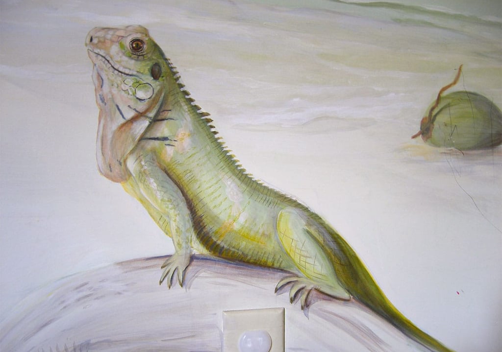 Close-up of a beach mural featuring a resting iguana with a coconut in the background