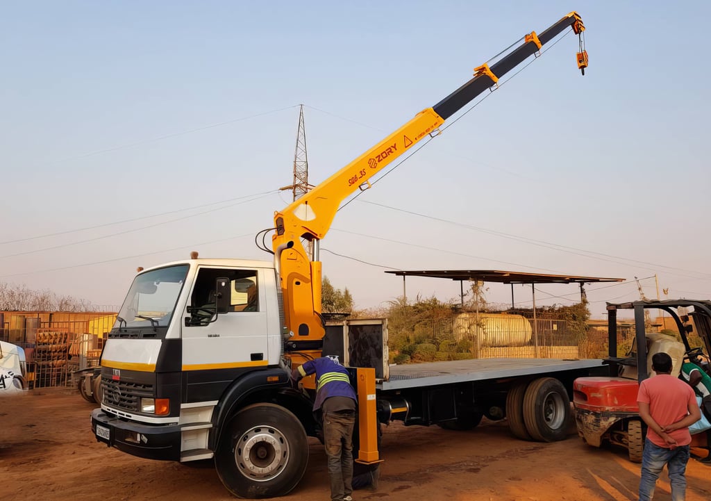 A telescopic boom truck mounted crane lifting a truck.