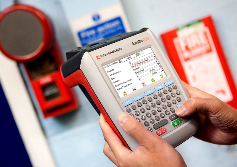 a person holding a portable appliance tester