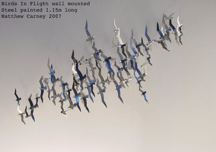 Steel sculpture of a flock of shearwaters in flight