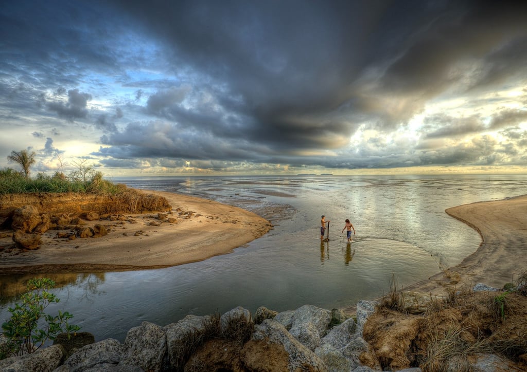 Deux jeunes pêcheurs tendent leur filet avant l'orage en Guyane