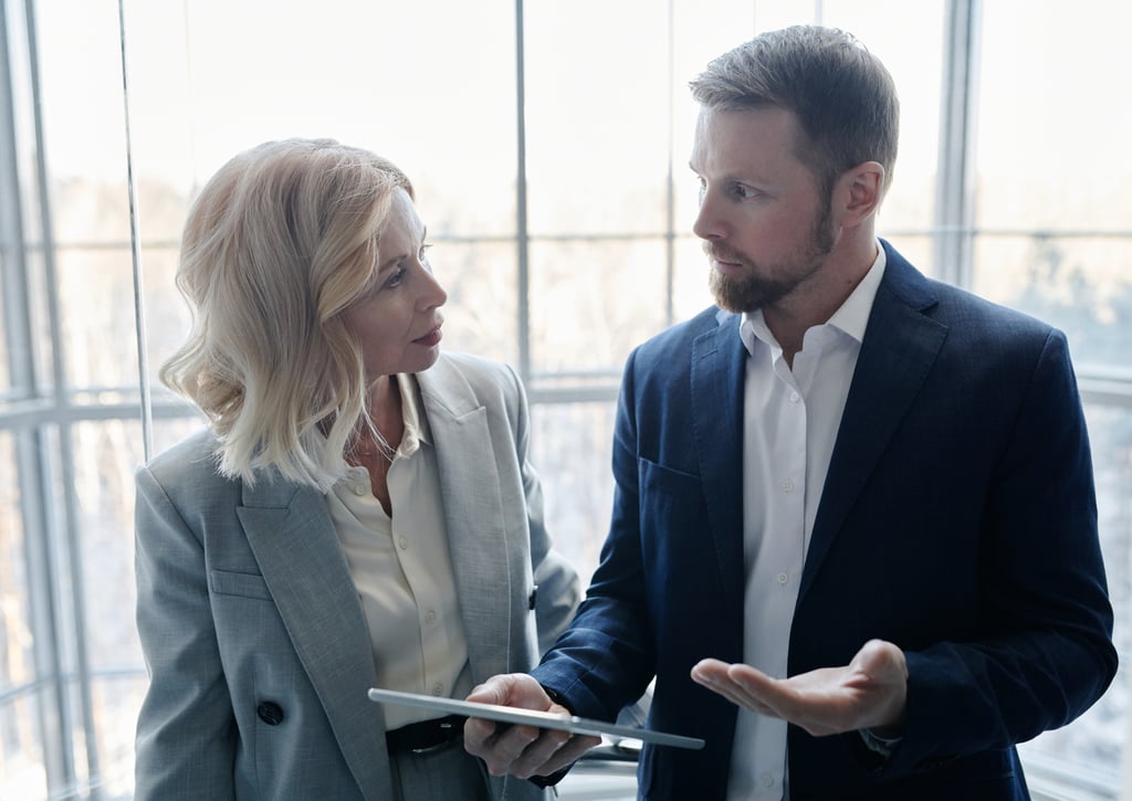 un hombre y una mujer de pie frente a una ventana