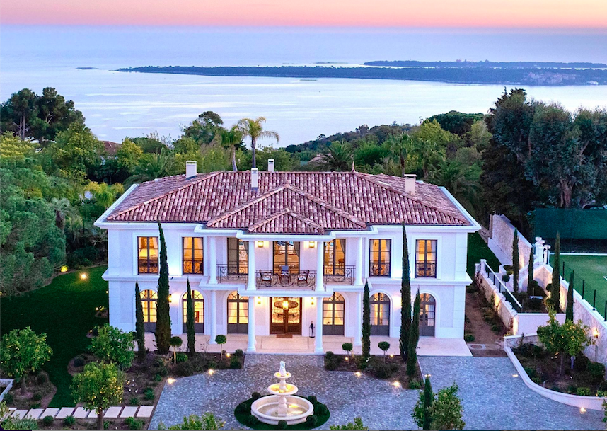 a large mansion with a fountain in the foreground