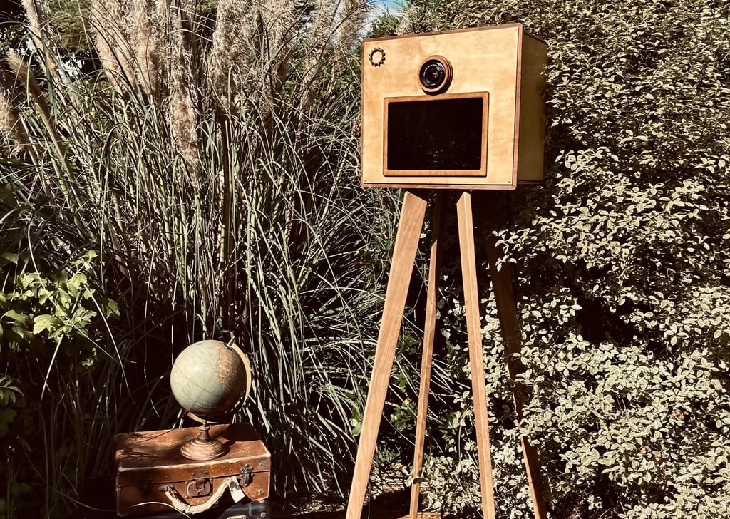 Photobooth en bois vintage installé en extérieur, sur trépied en chêne, intégré dans une scénographi