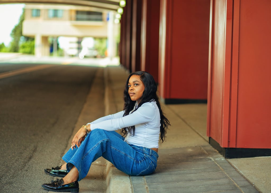 black woman relaxing sitting on a street curb