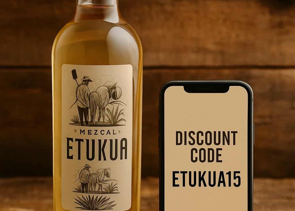 Botella de mezcal Etukua junto a un teléfono móvil que muestra un código de descuento en pantalla, s