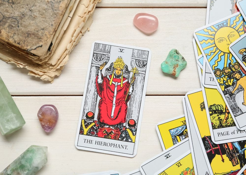 The Hierophant tarot card on a stack with crystals for tarot study and learning.