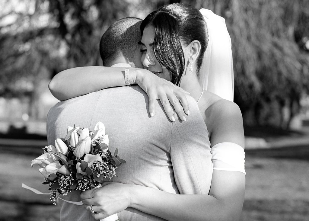 Photo en noir et blanc d'une mariée tenant un bouquet et enlaçant son époux lors d'un mariage en ple