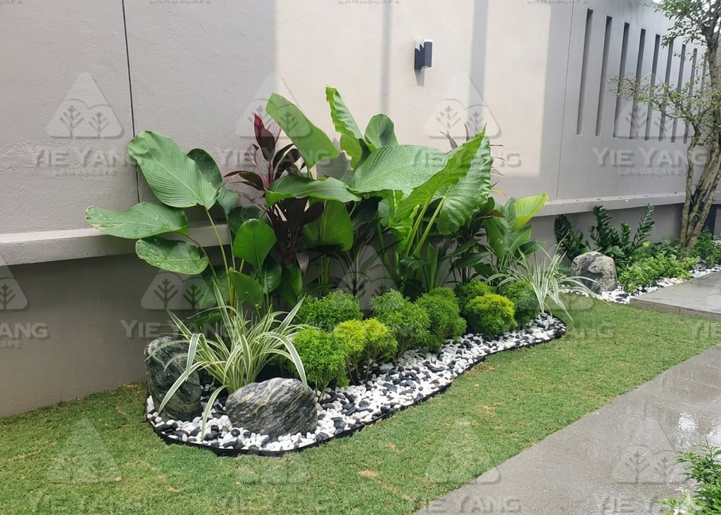 Tropical garden bed with white pebbles and artificial turf – Yie Yang Landscape