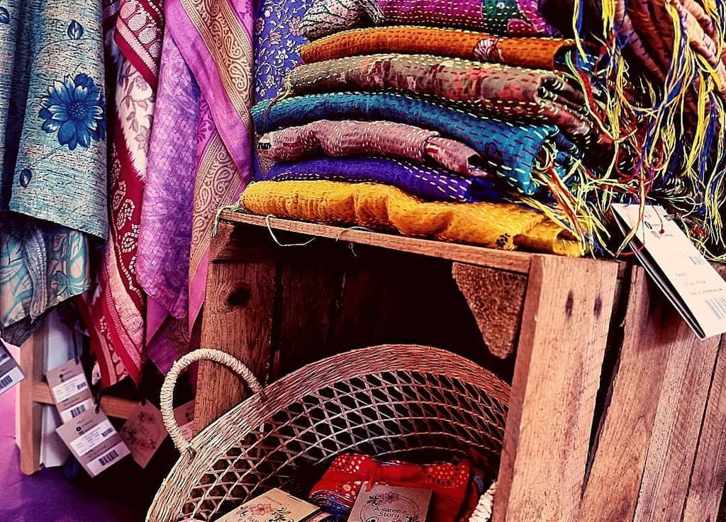 Folded vintage Indian sarees stacked in warm, earthy tones.