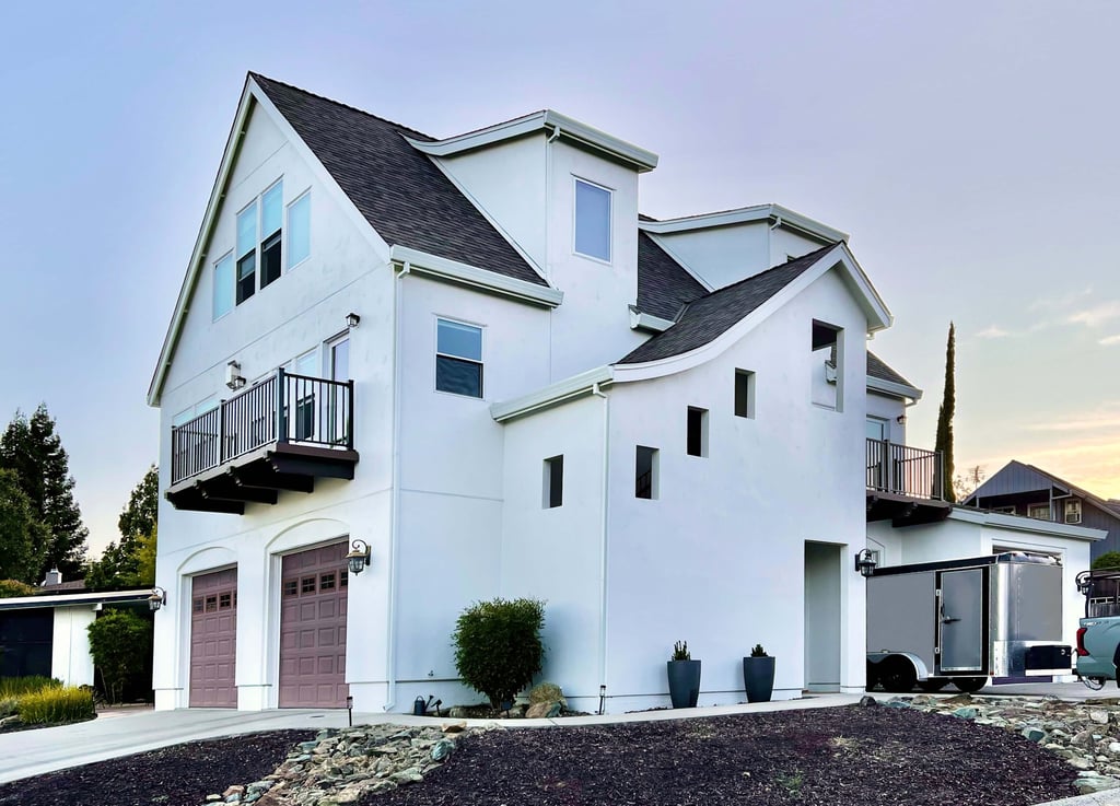 Corner perspective of a beautiful white French Revival architecture home.
