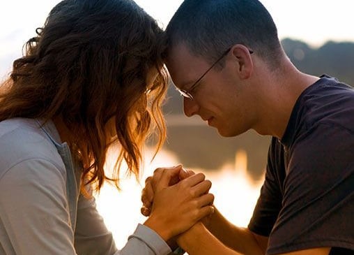 A married couple praying together