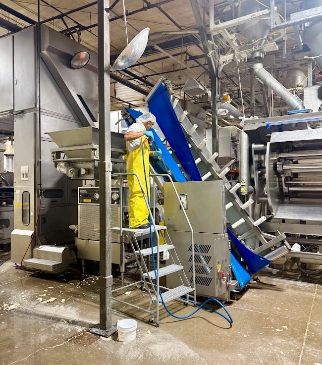 PRECISION CLEANING SERVICES SPECIALIST SANITIZES A HOPPER PER GMP REQUIREMENTS
