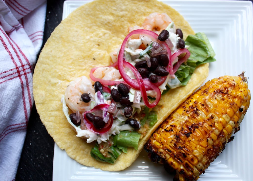 shrimp taco with beans, pickled onions and creamy coleslaw with a side of Mexican corn