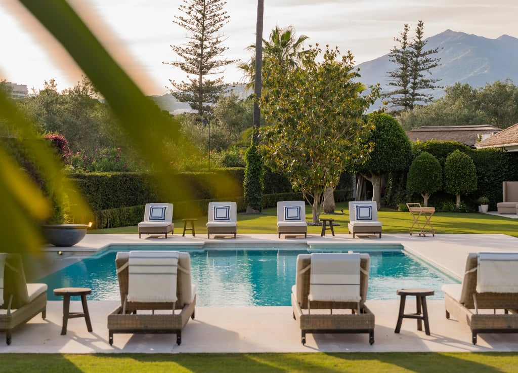 Sunlit pool terrace with lined sunbeds