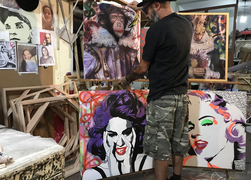 Ambiente criativo do ateliê, com o artista trabalhando em detalhes de uma obra complexa.