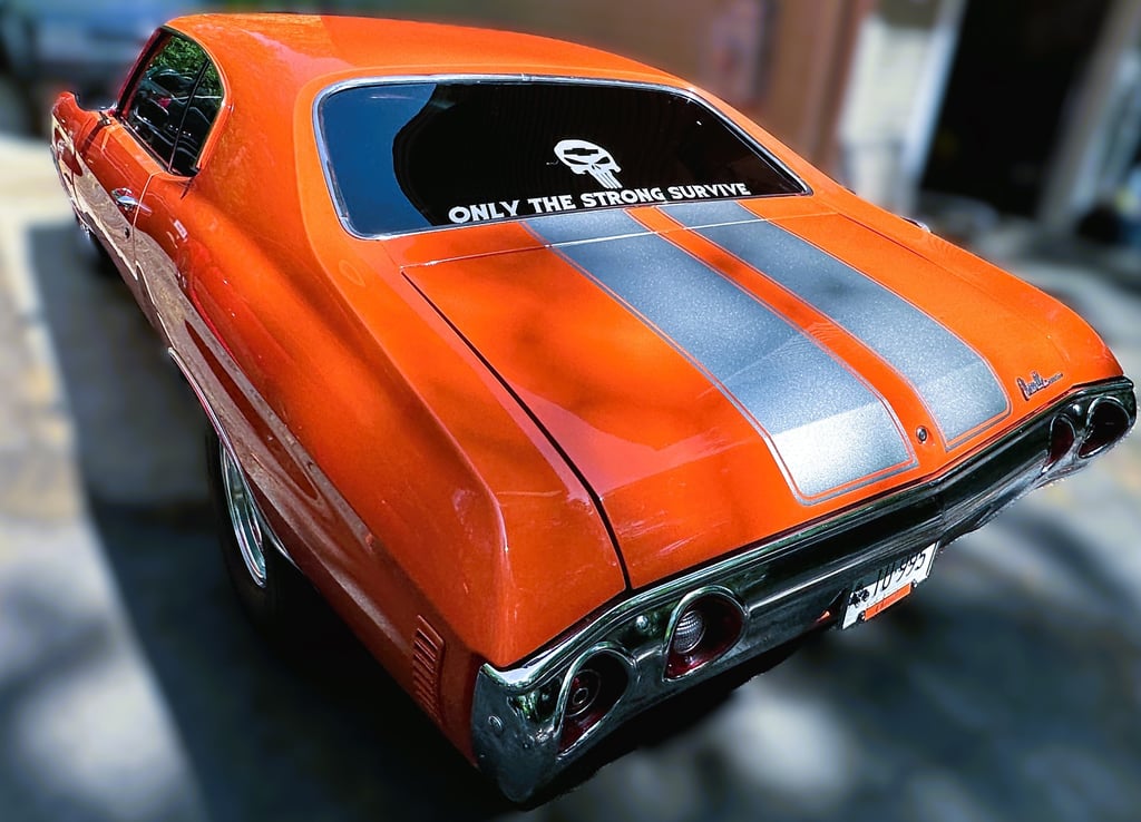 mobile detailing of a orange muscle car with grey stripes glossy in the sun