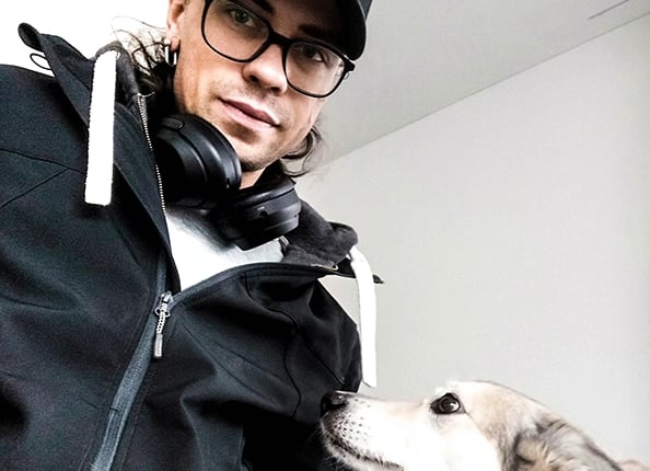 man with glasses and black baseball cap with gray dog