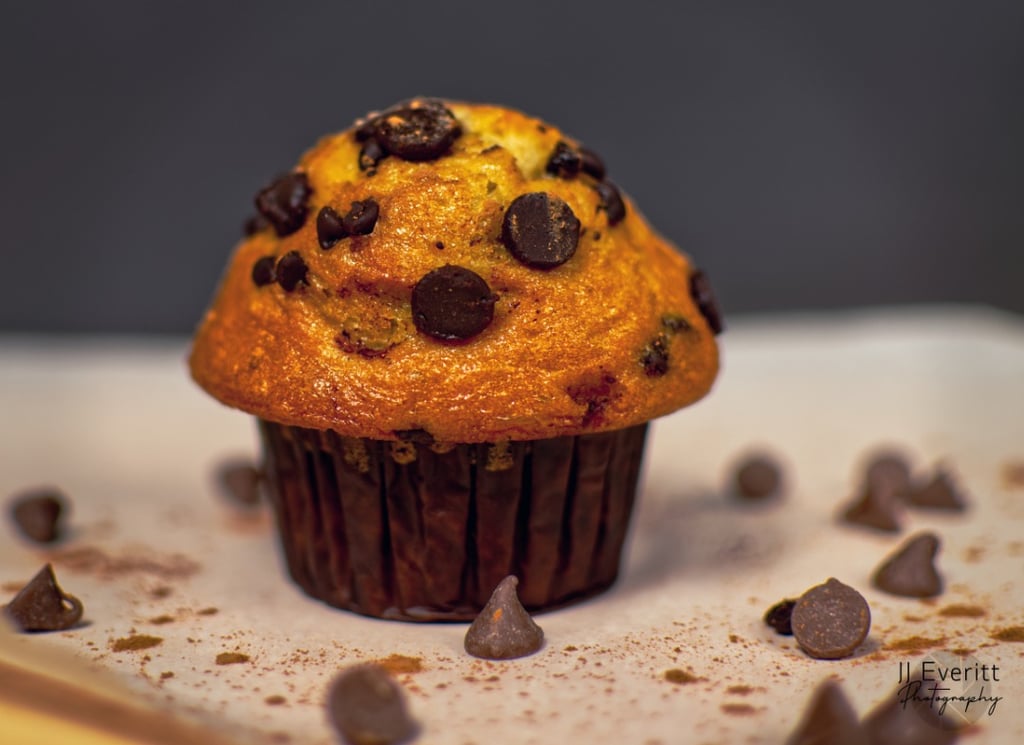 a chocolate chip muffin with chocolate chips on the side