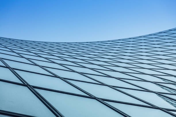 a building with a glass facade and a blue sky