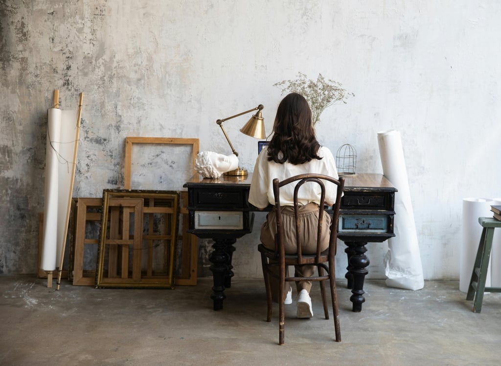 Mulher sentada à escrivaninha (Visão de costas)