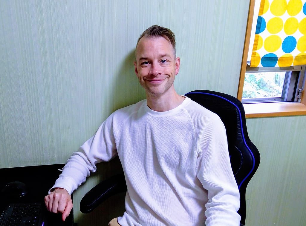 an online English teacher sitting at a computer desk