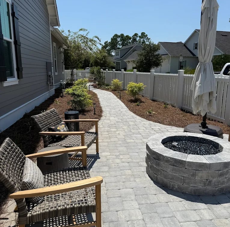 a patio with chairs and umbrellas in the yard